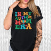 a woman wearing a black shirt with the words in my autism mom era on it