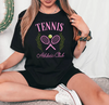 a woman sitting on a bed holding a tennis racket
