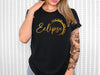 a woman wearing a black shirt with gold lettering