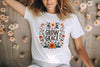 a woman laying on a bed of flowers wearing a t - shirt that says grow